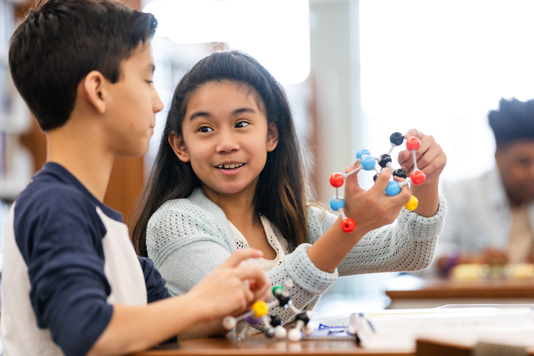 Two students examine a molecular model together during a hands-on science session.