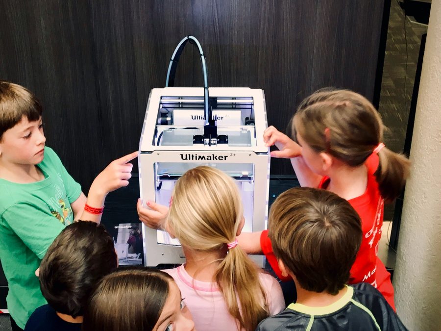 Students gathered around a 3D printer.