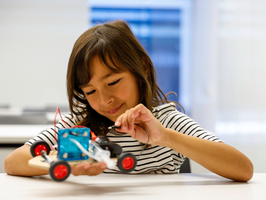 A student assembles and wires her model car at a Future Innovators session with Hyundai.